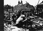 Family sits in rubble