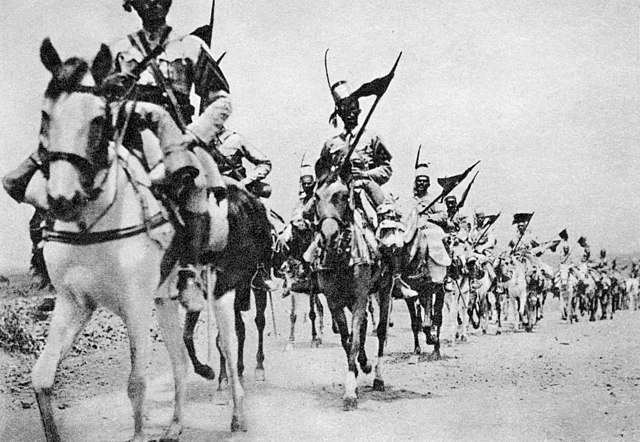(Italian colonial troops advancing into Addis Ababa on horseback 1936, public domain, Albertomos postcards collection)